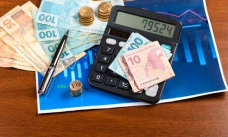 Dinheiro, cédulas de 10, 50 e 100 reais, moeda real, calculadora, gráfico financeiro