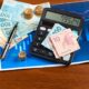 Dinheiro, cédulas de 10, 50 e 100 reais, moeda real, calculadora, gráfico financeiro