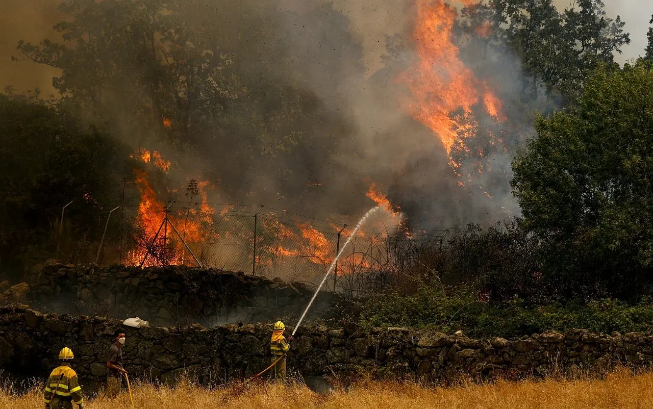 EL TIEMBLO, SPAIN - JULY 24: Firefighters and civillians attempt to extinguish a wildfire as it approaches houses on July 24, 2026 in El Tiemblo, in Ávila province, Spain. The Spanish interior minister declared a state of emergency as more than 11,500 people were forced to evacuate their homes to wildfires across the country. (Photo by Pablo Blazquez Dominguez/Getty Images)