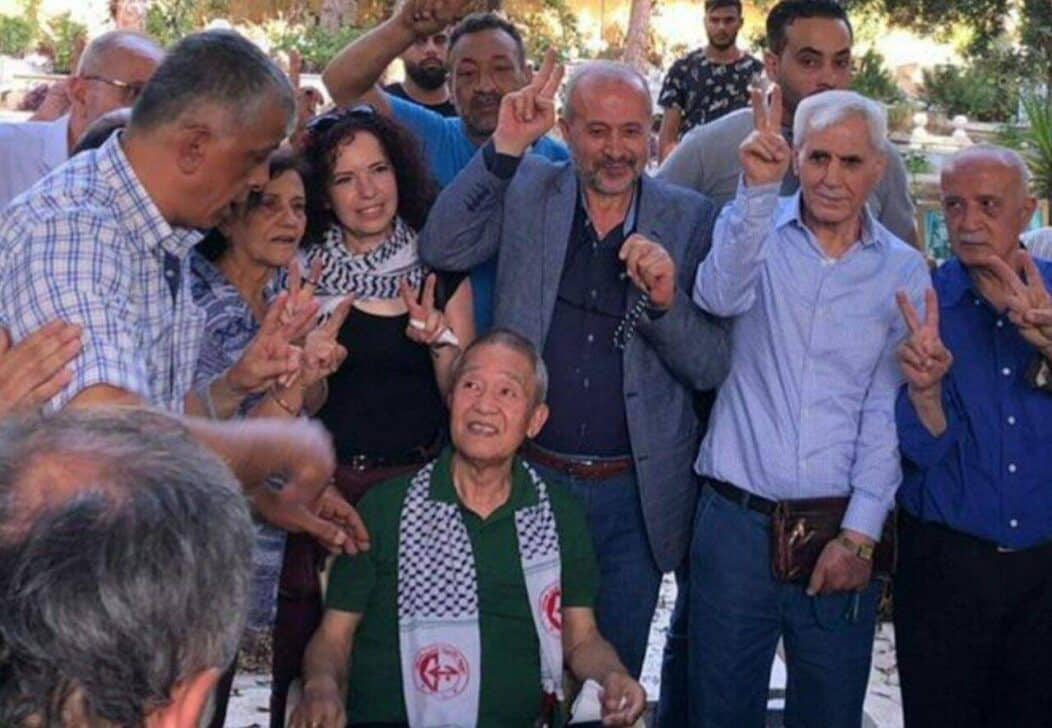 O suspeito Kozo Okamoto (no centro da foto, embaixo) sorri com membros da Frente Popular para a Libertação da Palestina (FPLP) em uma cerimônia em memória das vítimas realizada em um cemitério palestino em Beirute, Líbano, em 30 de maio de 2022.