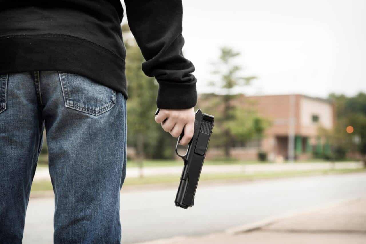 Adolescente segurando uma arma