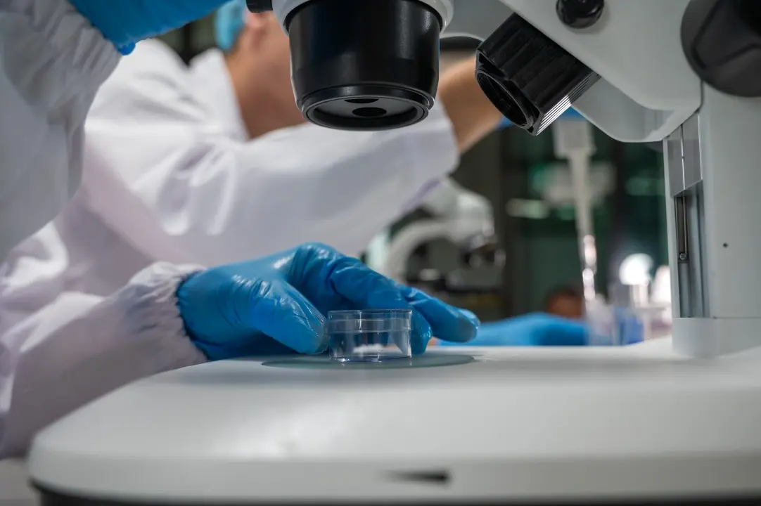 Biólogo, microscopio, laboratorio.