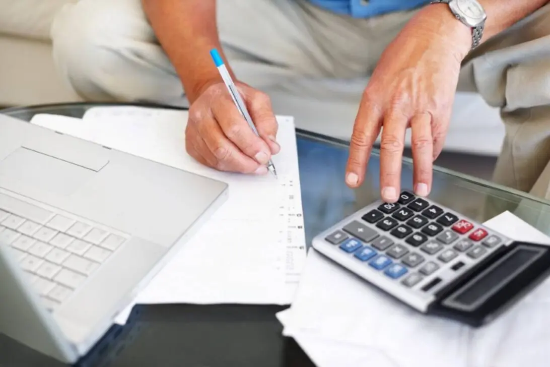 Homem no cálculo com laptop e calculadora, aposentadoria