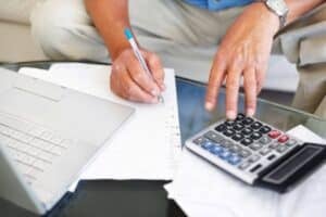 Homem no cálculo com laptop e calculadora, aposentadoria