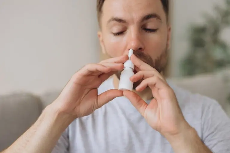 Homem usando spray nasal, conceito de rinite