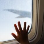 Mão de criança em janela de avião