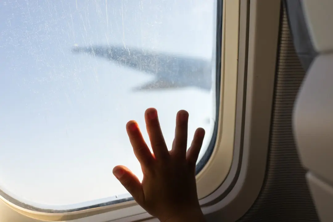 Mão de criança em janela de avião