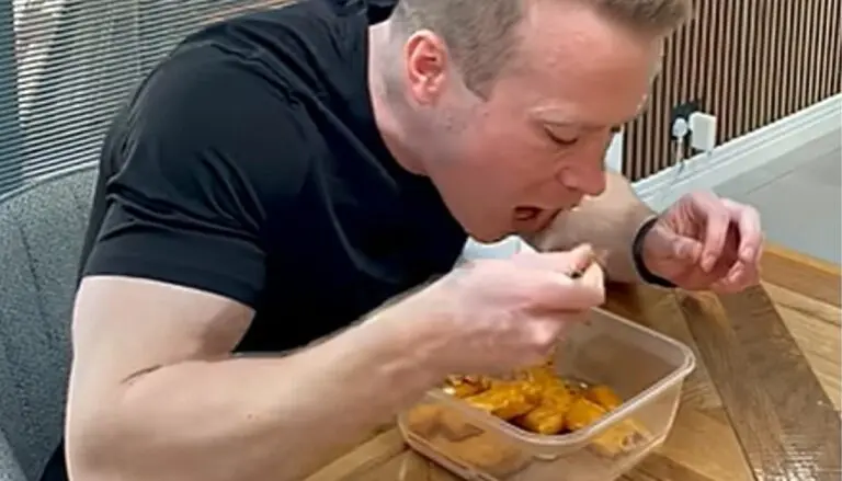 Homem comendo palitos de peixe