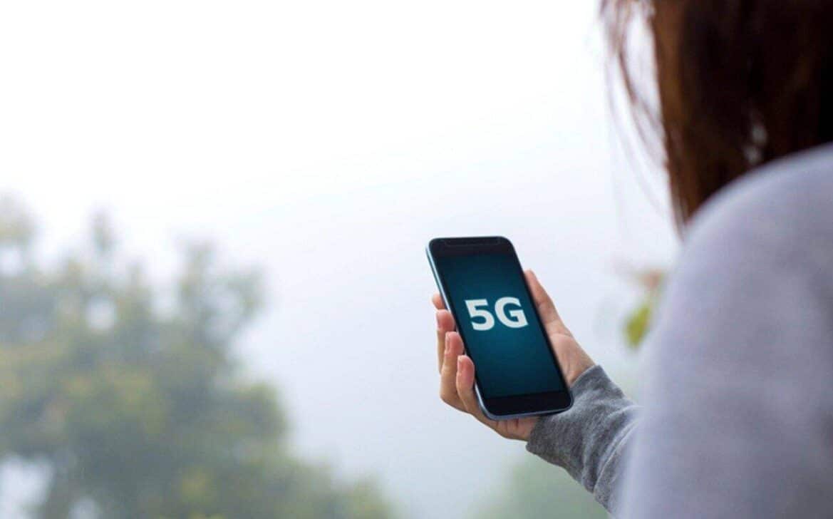Mulher segurando celular 5G - cokada/istockphoto