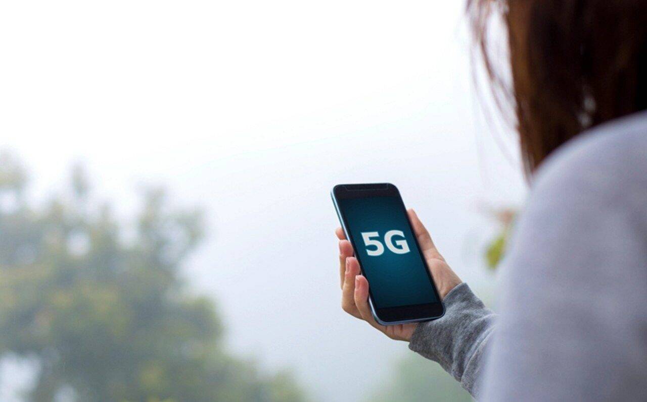Mulher segurando celular 5G - cokada/istockphoto