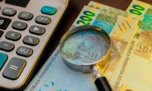 Dinheiro, real, lupa, calculadora - RODWORKS/shutterstock.com