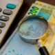 Dinheiro, real, lupa, calculadora - RODWORKS/shutterstock.com