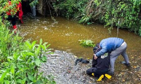 Filho de Édson Luís da Silva, 46 anos, é consolado à margem de arroio após corpo do pai ser encontrado - Neimar De Cesero/Agência RBS