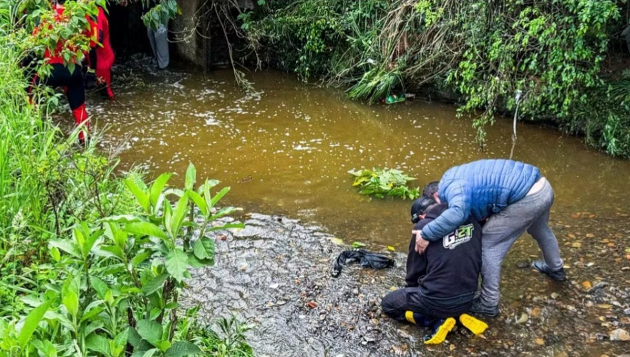 Filho de Édson Luís da Silva, 46 anos, é consolado à margem de arroio após corpo do pai ser encontrado - Neimar De Cesero/Agência RBS