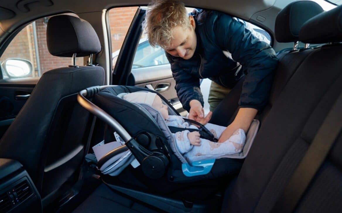 Homem colacando bebê na cadeirinha - Okrasiuk/Shutterstock.com