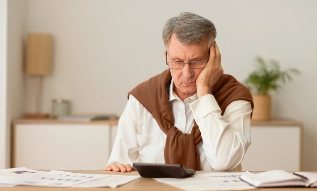 Homem idoso usando calculadora, papelada, conceito de contas, aposentadoria - Prostock-studio/Shutterstock.com
