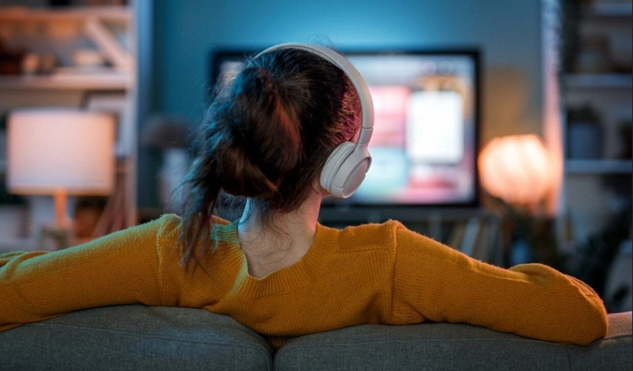 Mulher assistindo TV, televisão com fones - Yuganov Konstantin/Shutterstock.com