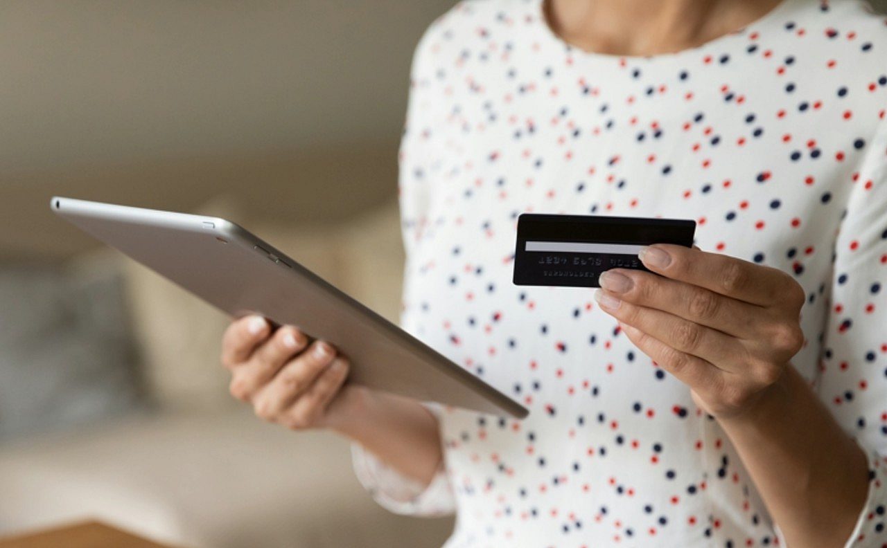 Mulher com tablet na m&atilde;o e cart&atilde;o de cr&eacute;dito, conceito de compra - fizkes/Shutterstock.com