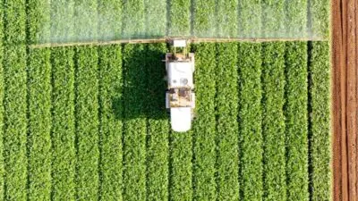 Trator pulveriza fertilizante em plantação - Foto: Depositphotos
