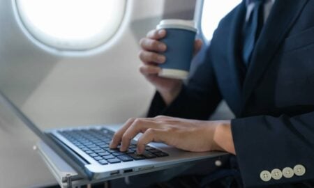 Homem de terno em avião com notebook, conceito de empresário de férias - THICHA SATAPITANON/shutterstock.com