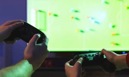 Homem e criança jogando vídeo game - New Africa/ shutterstock.com