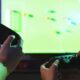 Homem e criança jogando vídeo game - New Africa/ shutterstock.com