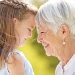 Menina criança e senhora idosa sorrindo - PeopleImagesistockphoto.com