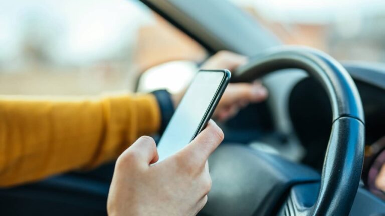 motorista usando celular enquanto dirige - bbernard/Shutterstock.com