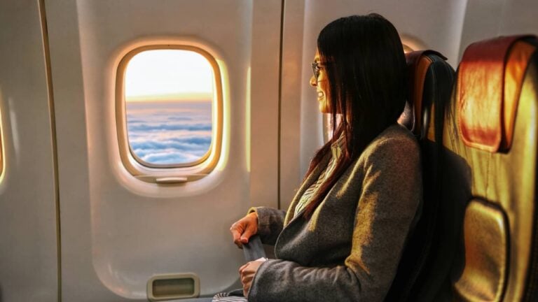passageira olhando pela janela do avião - Yaroslav Astakhov / shutterstock.com